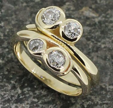 Two 18ct yellow gold two diamond wrap around shanked rings